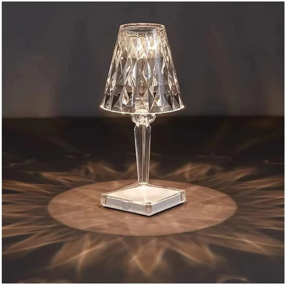 Crystal table lamp on a dark surface with a blurred background