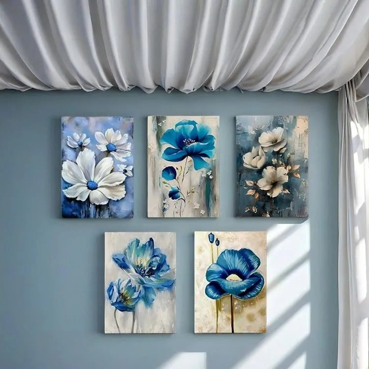Set of five floral paintings with blue and white flowers on a gray wall.