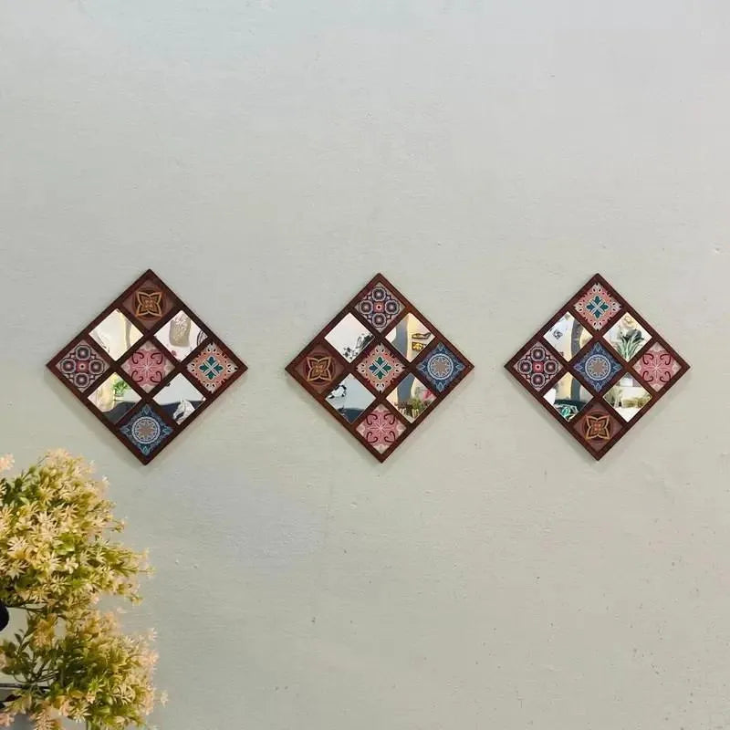 Three decorative wall art pieces with a patchwork design on a light gray wall.