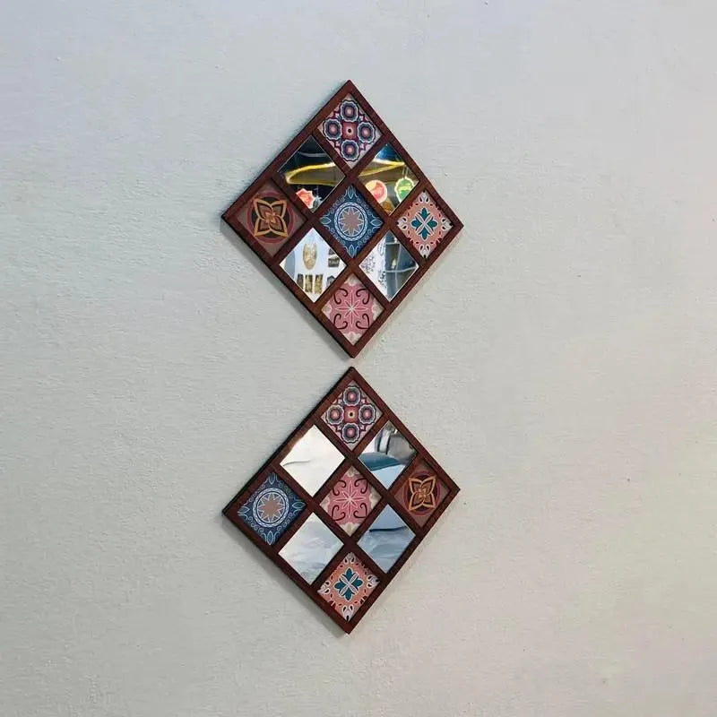 Two decorative wall mirrors with a geometric design on a plain wall.