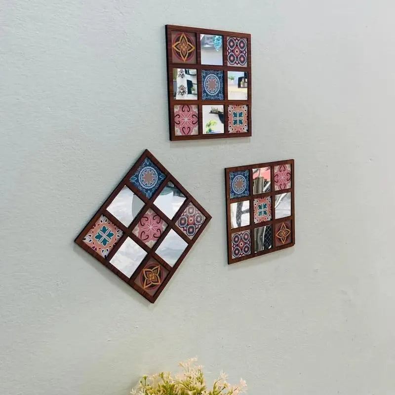 Three decorative wall mirrors with mosaic designs on a light gray wall.