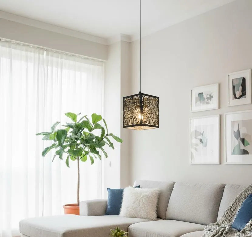 Modern living room with a gray sectional sofa, decorative pillows, a plant, and wall art.