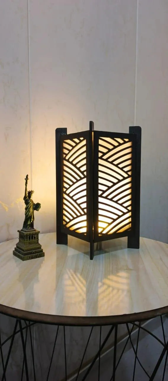 Decorative lamp with wavy pattern on a round table against a white wall