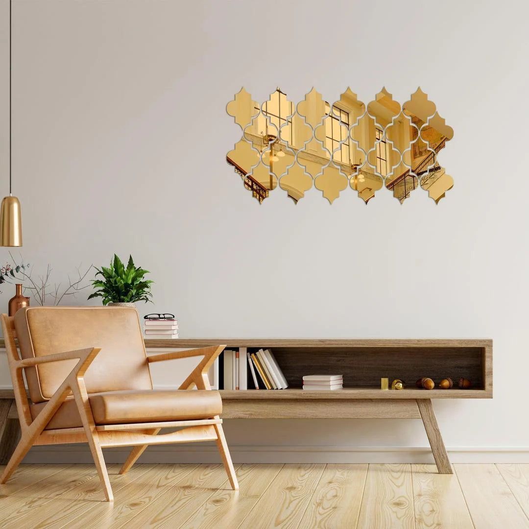 Decorative gold wall mirror in a modern living room setting with a beige armchair and wooden coffee table.