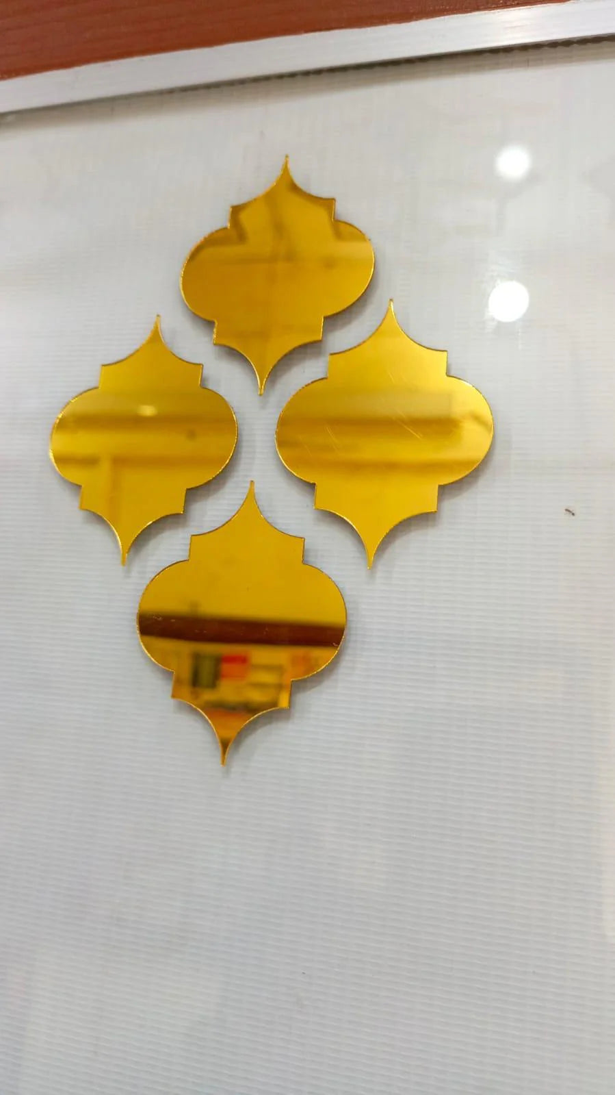 Gold decorative mirror shapes on a white wall