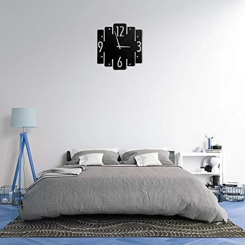 Modern wall clock on a white wall above a bed in a bedroom.