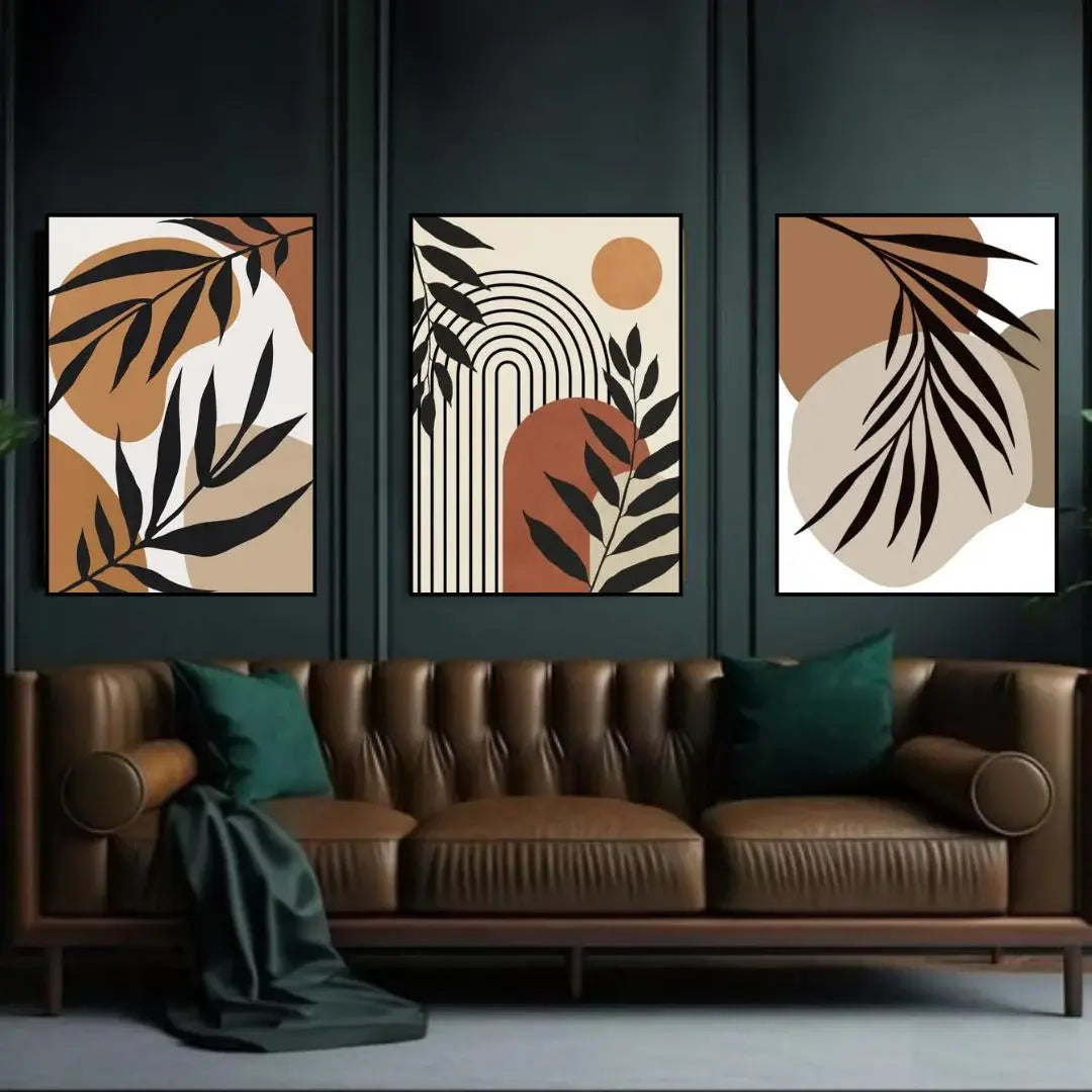 Three abstract art pieces on a wall above a brown sofa with green cushions.