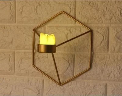 Geometric wall-mounted candle holder with a lit candle on a textured wall background