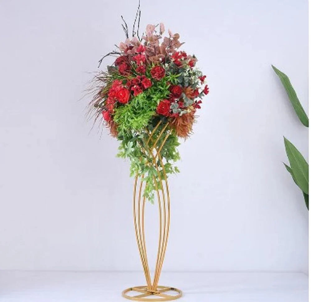 Floral arrangement on a gold stand against a white background