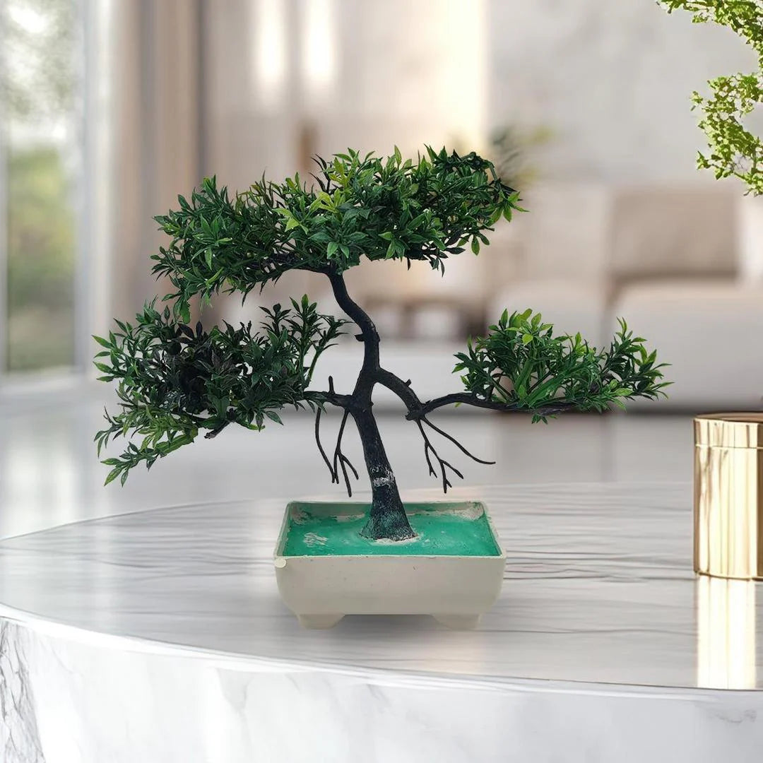 Artificial bonsai tree in a pot on a reflective surface with a blurred indoor background