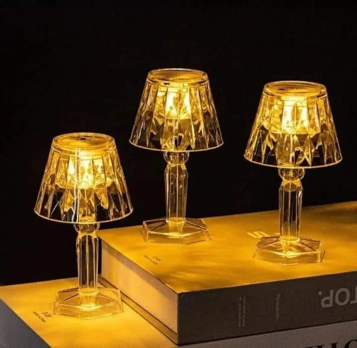 Three small table lamps with a warm glow on a dark background