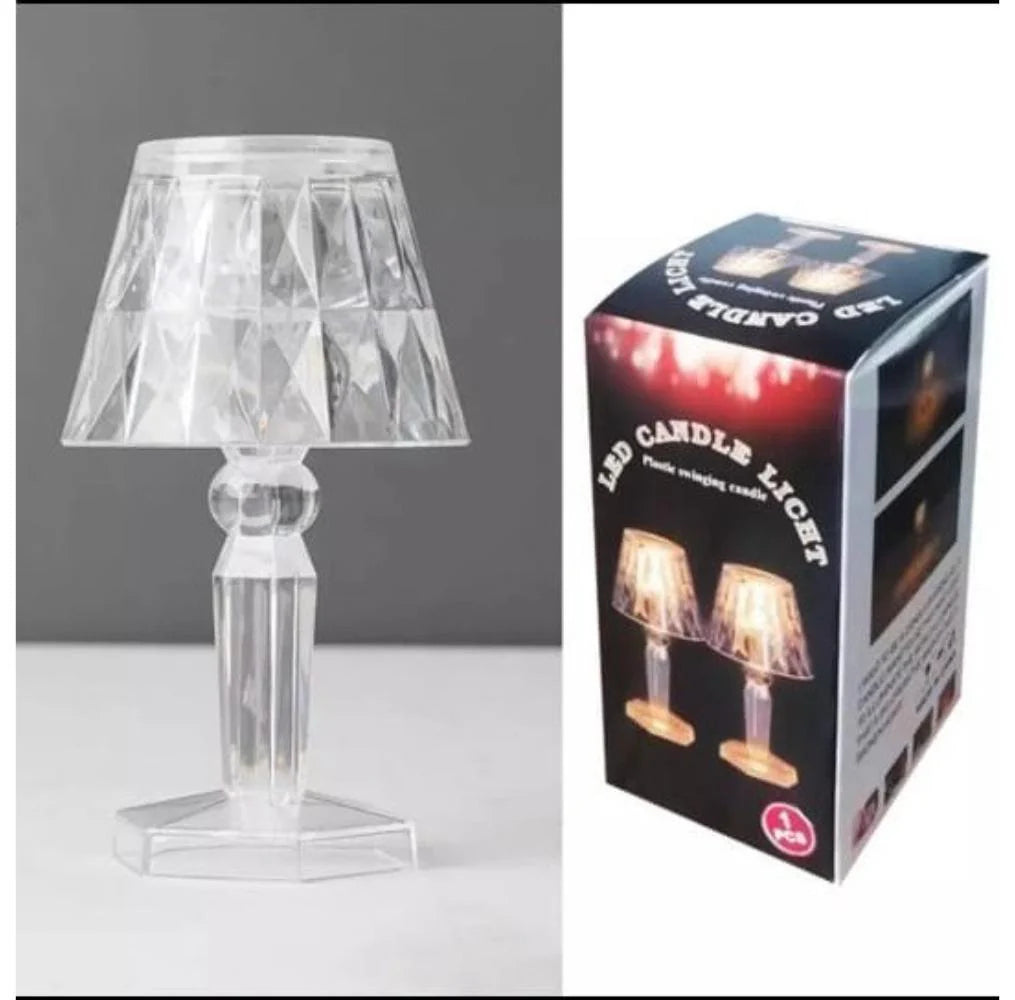 Clear table lamp next to its packaging box on a white background
