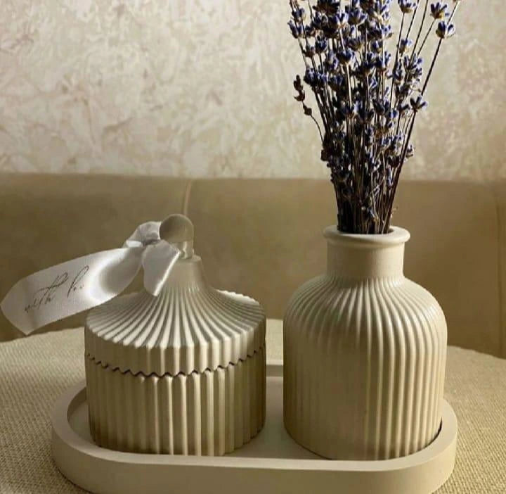 Two beige ceramic containers with a dried lavender arrangement on a neutral background