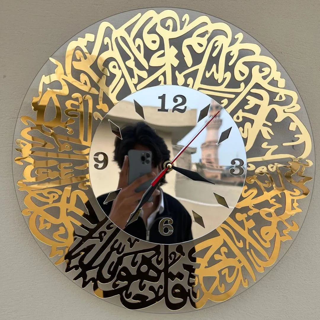 Decorative clock with gold and black calligraphy on a gray background