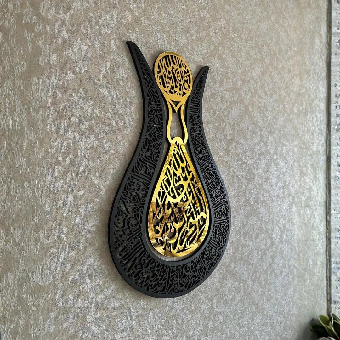 Decorative wall art with gold and black design on a textured wall