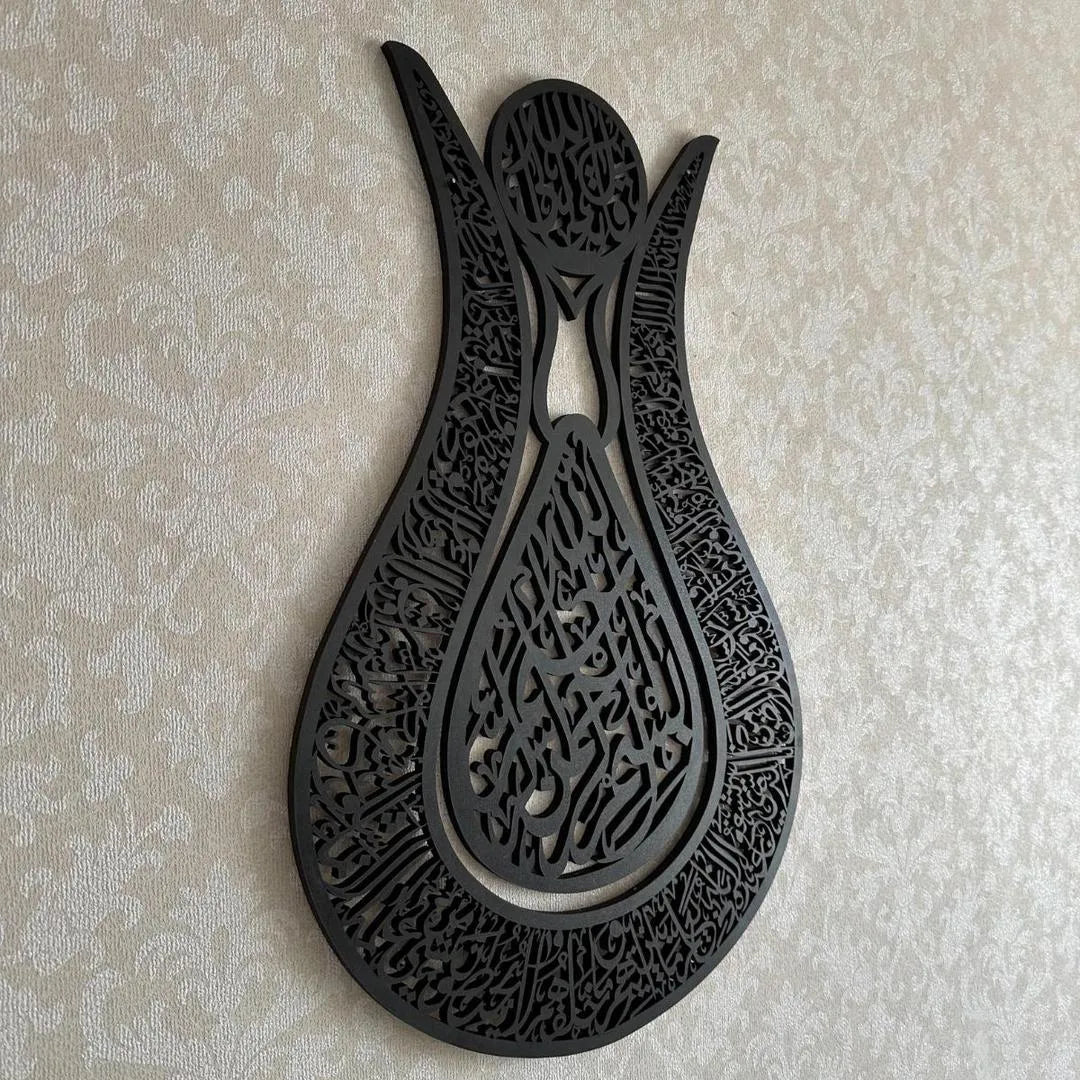 Decorative black metal wall art with intricate patterns on a beige textured background