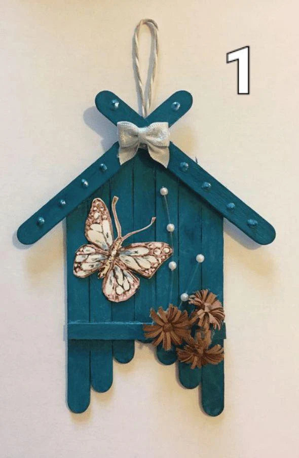 Decorative hanging craft with butterfly and pinecones on a plain background