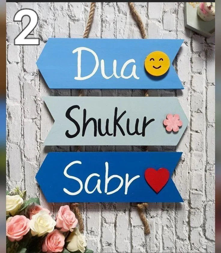 Decorative wall art with motivational phrases 'Dua', 'Shukur', and 'Sabr' on colorful arrows with emojis.