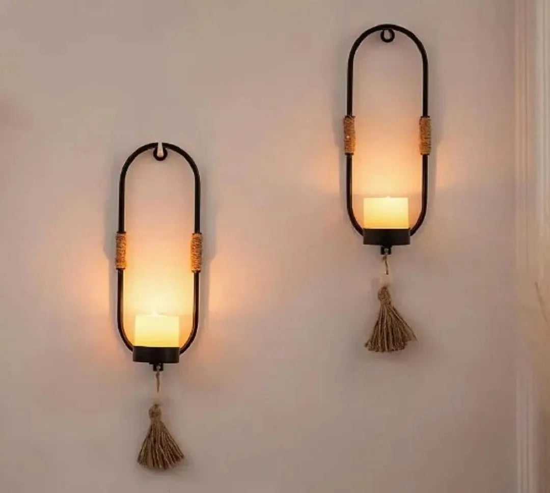 Two wall-mounted lanterns with tassels on a plain wall.