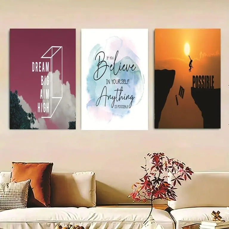 Three motivational posters on a wall above a sofa with decorative pillows and a plant.