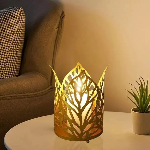 Decorative candle holder on a table with a warm glow, next to a plant and a cushioned chair.