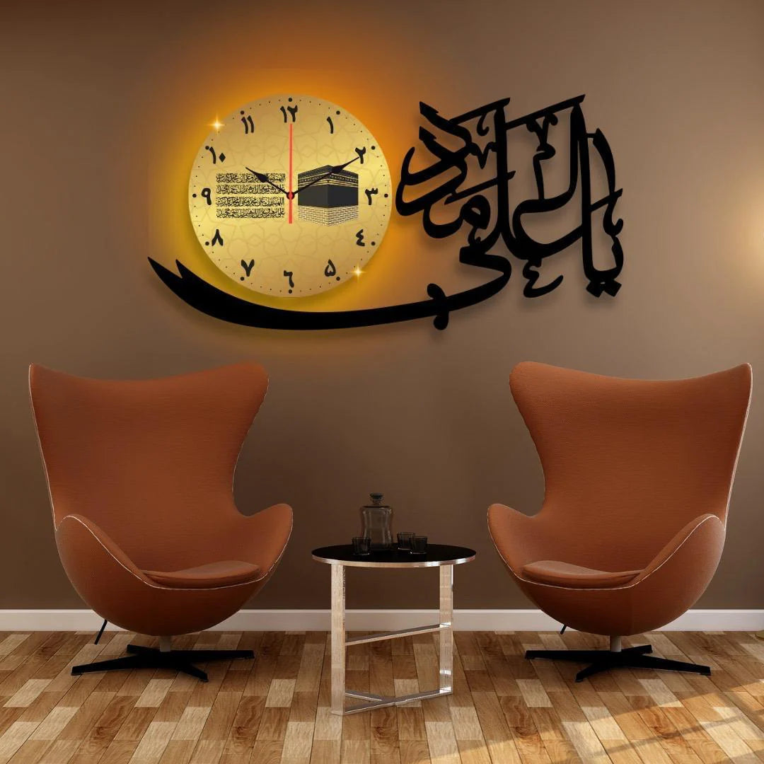 Decorative wall clock with Arabic calligraphy and a mosque illustration in a room with two orange chairs and a small table.