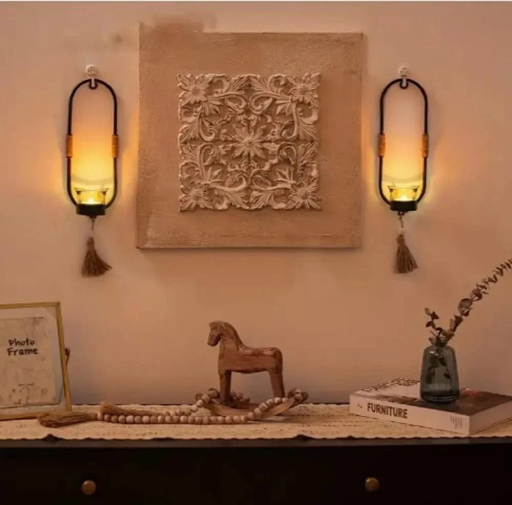 Decorative wall sconces with a textured wall art piece and small items on a table.